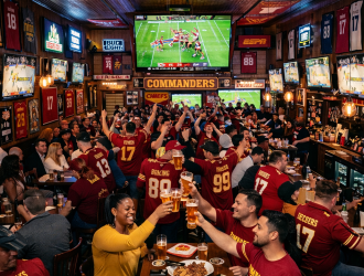 Crowd of sports fans watching football on multiple screens at a packed bar